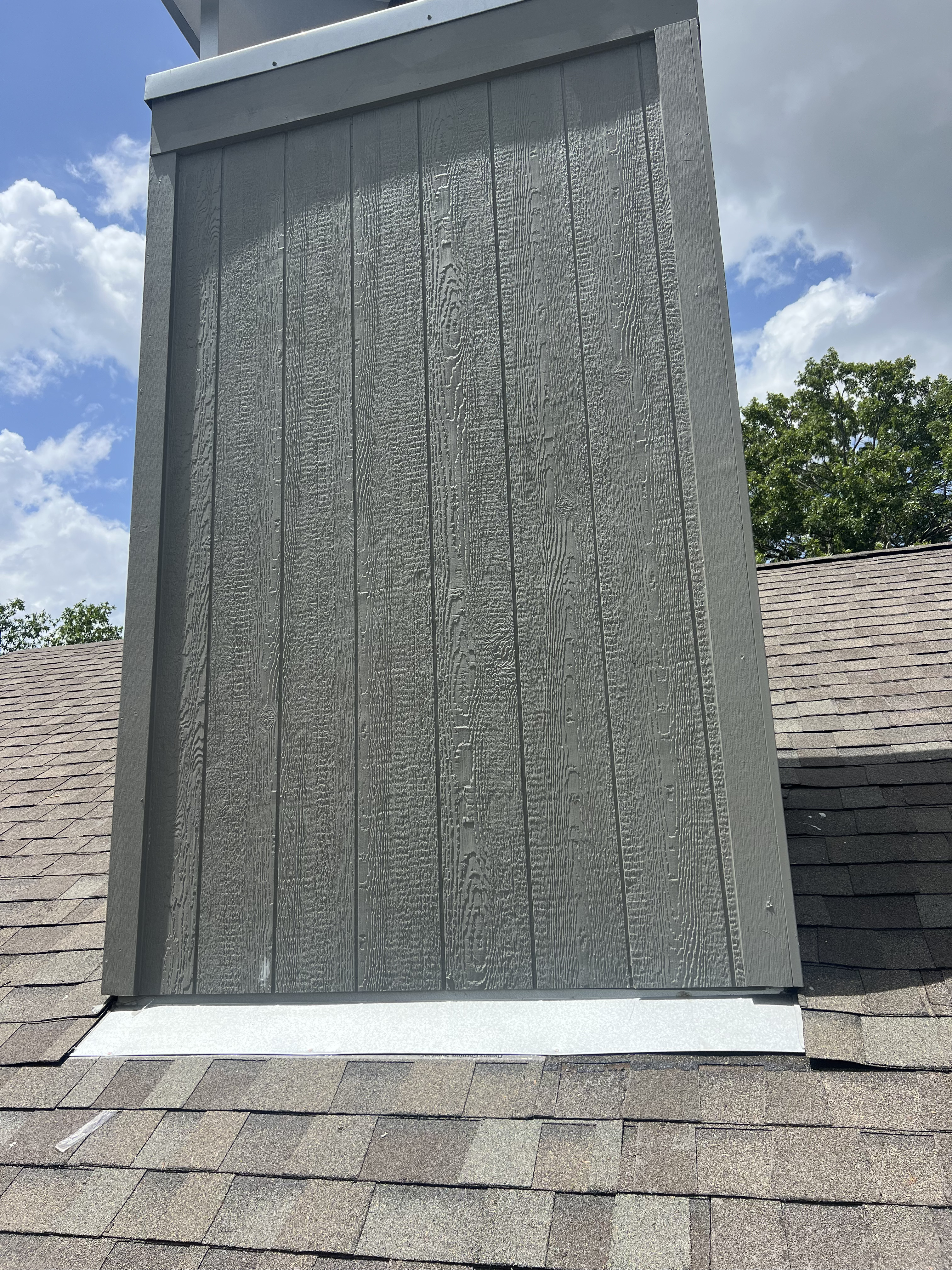 After photo of a New Braunfels, TX chimney with finished cladding and clean trim after repair by Tex-Mex Roofing.