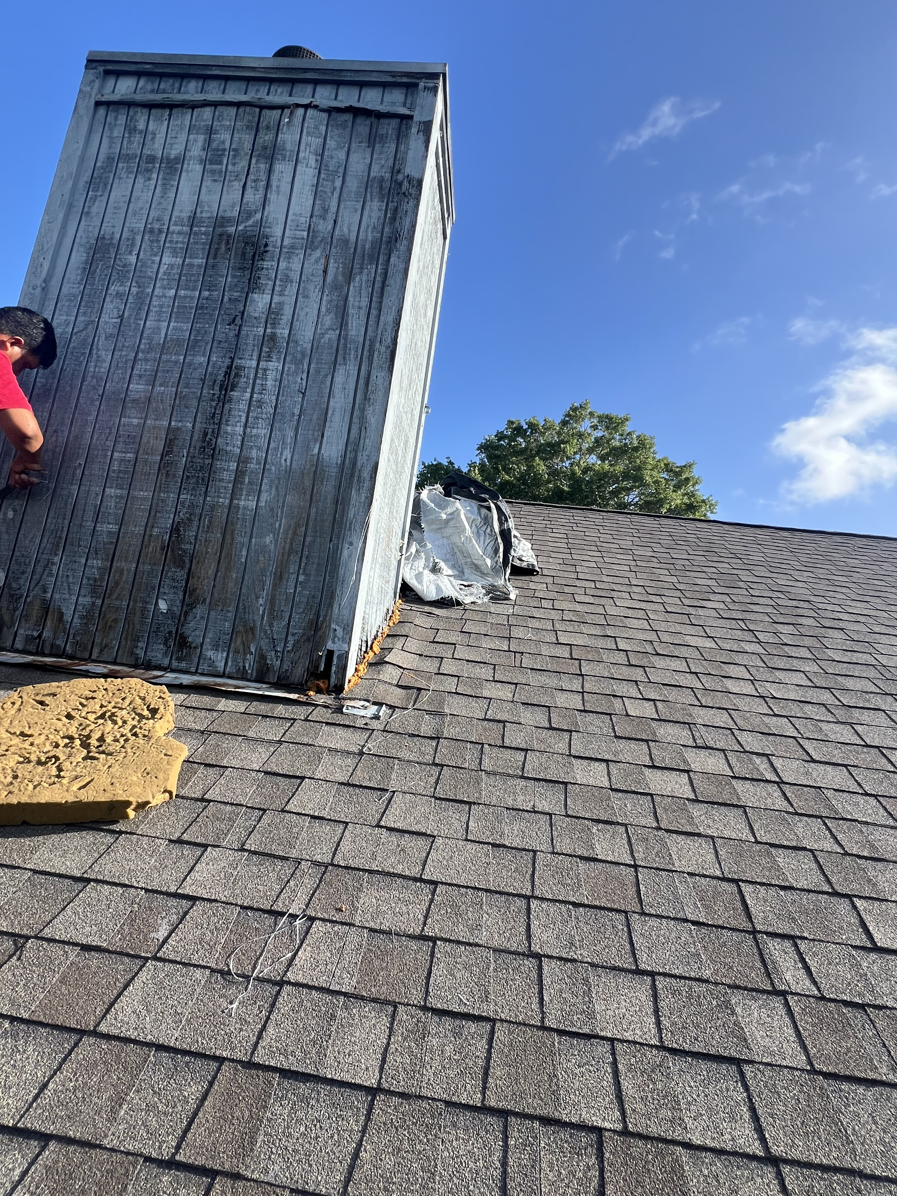 Before photo of a deteriorated chimney in New Braunfels, TX with weathered exterior panels before repair.