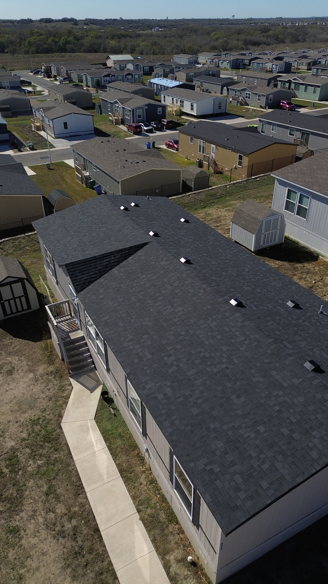 Aerial after photo of a Kyle, TX home with a finished dark architectural shingle roof installed by Tex-Mex Roofing.