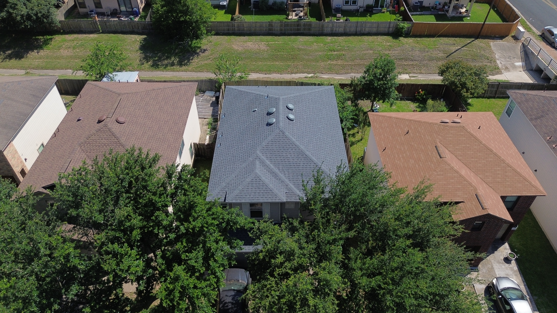 Aerial after photo of an Austin, TX home with a brand-new gray architectural shingle roof installed by Tex-Mex Roofing.