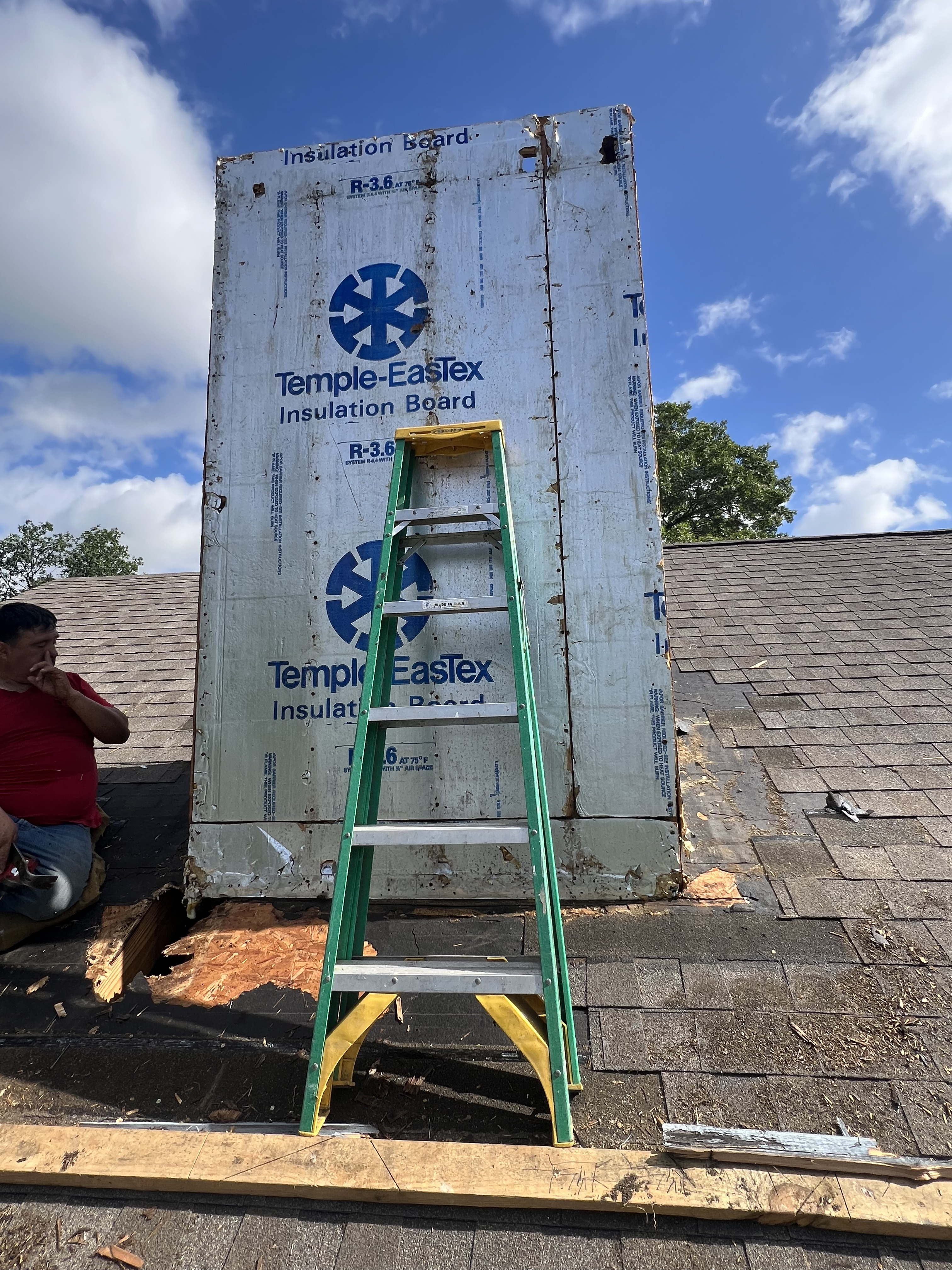 Before photo of a New Braunfels, TX chimney during chimney repair with exposed insulation board and flashing work in progress.